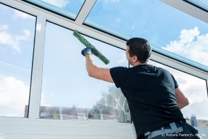 Professionelle Reinigungskraft pflegt Fenster